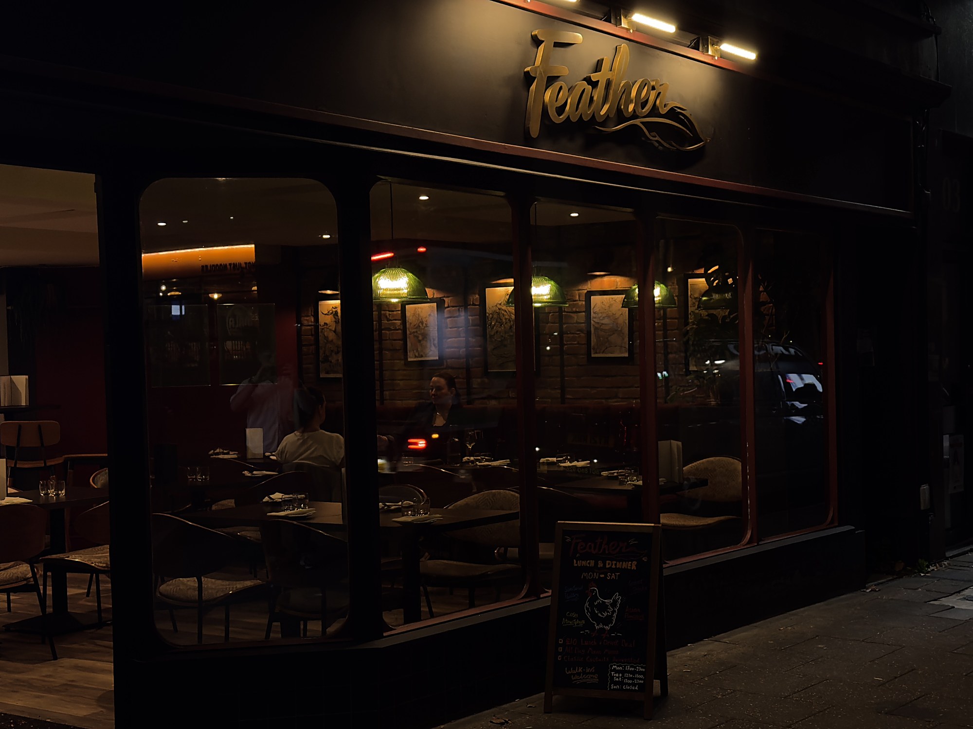 Feather's shopfront on Whiteladies Road: black frontage, red window frames and the gold script sign.