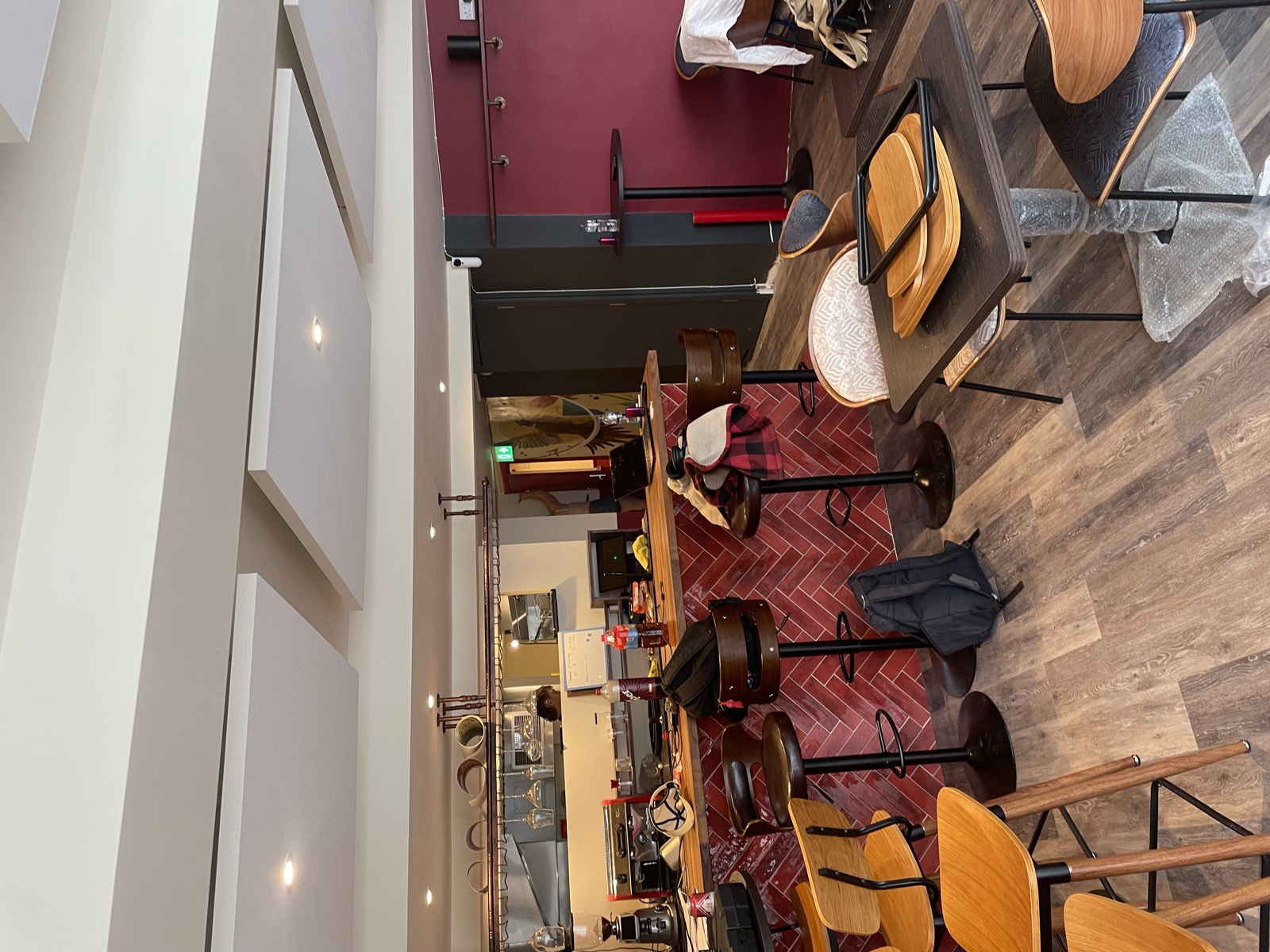 The finished dining room: red herringbone bar, walnut tables, brick wall.