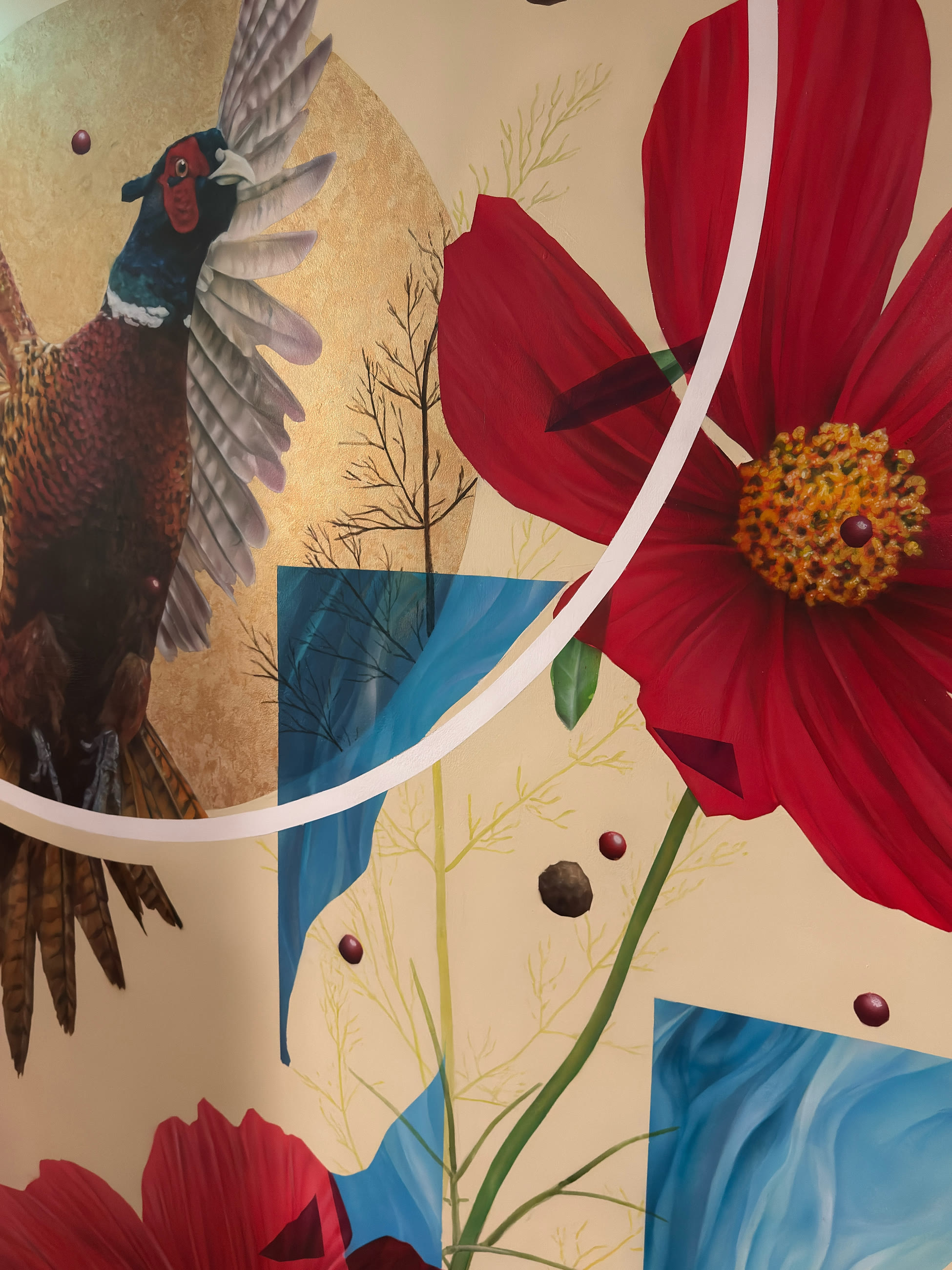 The dining-room mural: a cock pheasant in flight across a disc of gold leaf, among oversized red cosmos flowers.