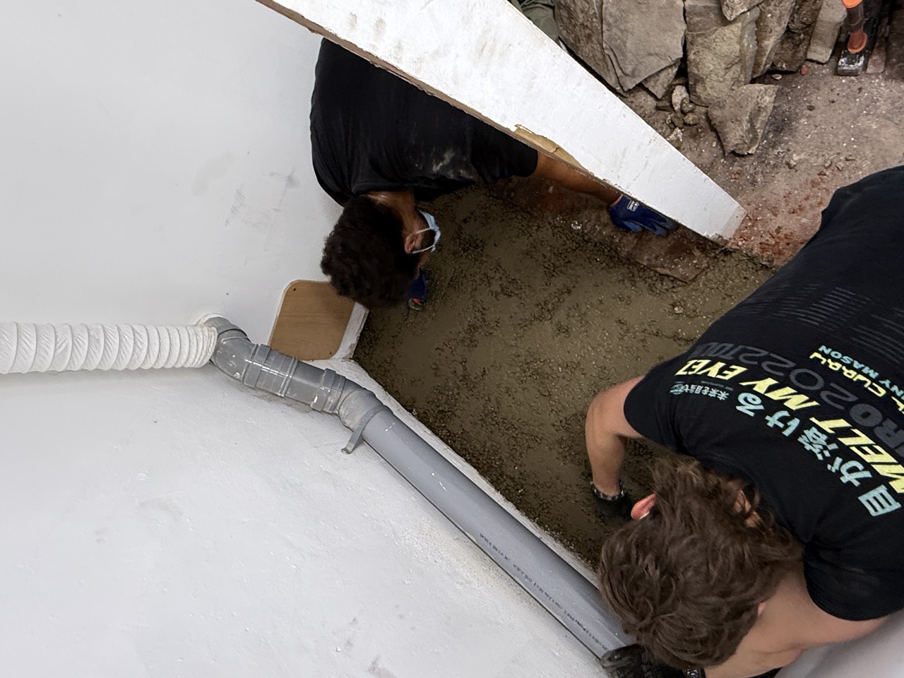 The two of us cutting a drainage channel into the floor slab by hand.