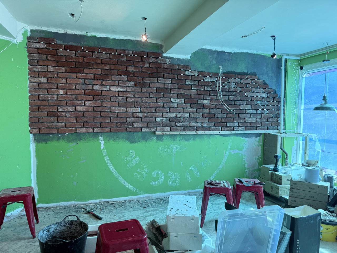 The original brick wall uncovered from behind the old green paint.