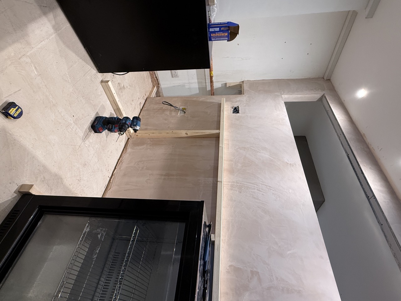 The bar carcass in place against the microcement back wall.