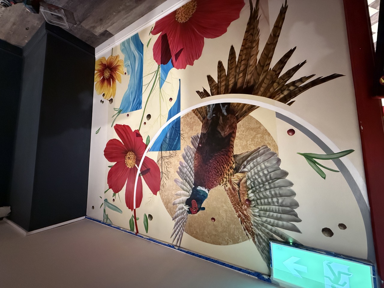The pheasant mural almost finished, red cosmos flowers filling in.